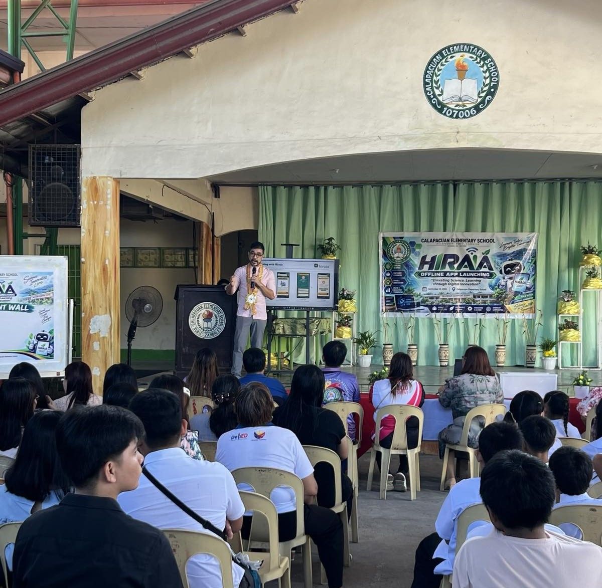A speaker presenting Hiraia to a seated audience at Calapacuan Elementary School